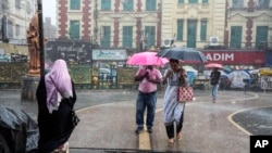 কলকাতায় বৃষ্টির মধ্যে হাঁটছে মানুষ। 