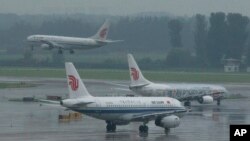 资料照 - 北京国际机场，中国国际航空公司一架飞机正在降落，另外两架正在等待空管的调度准备起飞。