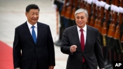 Chinese President Xi Jinping, left, and Kazakhstan's President Kassym-Jomart review an honor guard during a welcome ceremony at the Great Hall of the People in Beijing, Sept. 11, 2019.