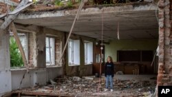 Учениця стоїть на руїнах свого класного приміщення в Михайло-Коцюбинському ліцеї на Чернігівщині, по якому російські сили завдали ракетного удару в березні 2022 р. (AP Photo/Emilio Morenatti)