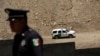 A Mexican police officer stands next to a bollard-type wall along the border of a private property, built using funds raised from a GoFundMe account, at Sunland Park, New Mexico, as a border patrol vehicle is seen, from Ciudad Juarez Mexico May 29, 2019…