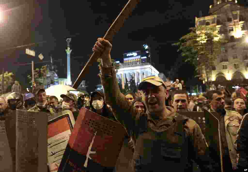 Self-defense volunteers stand at the barricade of their tent camp as Ukrainian nationalists attempt to walk into the square in Kyiv, April 29, 2014.
