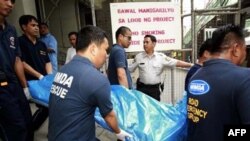 Nhân viên cứu hộ khiêng xác các nạn nhân ra khỏi công trình xây dựng nhà cao tầng ở Manila, ngày 27/1/2011