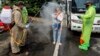 La police désinfectant des citoyens vénézuéliens de retour de Colombie, à titre préventif contre la propagation du coronavirus, au pont Simon Boliviar, Cucuta, 4 avril 2020. (Photo Schneyder Mendoza/AFP)