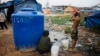 FILE PHOTO - A Cambodian bathes near his slum home Thursday, Feb. 19, 2009, on the outskirts of Phnom Penh, Cambodia. (AP Photo/David Longstreath)