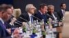 U.S. President Barack Obama, seated right, talks with British Prime Minister David Cameron, 2nd right, before the start of a session of the North Atlantic Council at PGE National Stadium in Warsaw, Poland, Saturday, July 9, 2016.