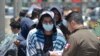 Oficiales de la Patrulla Fronteriza de Estados Unidos devuelven a un grupo de migrantes de regreso al lado mexicano de la frontera, mientras los funcionarios de inmigración revisan la lista en Nuevo Laredo.