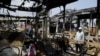 People look at burned-out buses in Lagos, Oct. 24, 2020. Nigeria's president says 51 civilians have been killed in unrest following days of peaceful protests over police abuses, and he blames "hooliganism" for the violence.