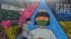 Seorang pejalan kaki berjalan dekat mural yang menggambarkan seorang perawat sebagai tanda dukungan kepada para medis yang menjadi garda terdepan penanganan wabah virus corona (COVID-19) di Ciamis, Jawa Barat, 10 April 2020. (Foto: Reuters)