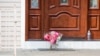 Ramos de flores fueron dejados en la puerta de la casa de un rabino en Monsey, Nueva York, el domingo 29 de diciembre de 2019, tras un ataque con cuchillo en la residencia el sábado por la noche, que dejó cinco heridos. AP/Julius Constantine Motal.
