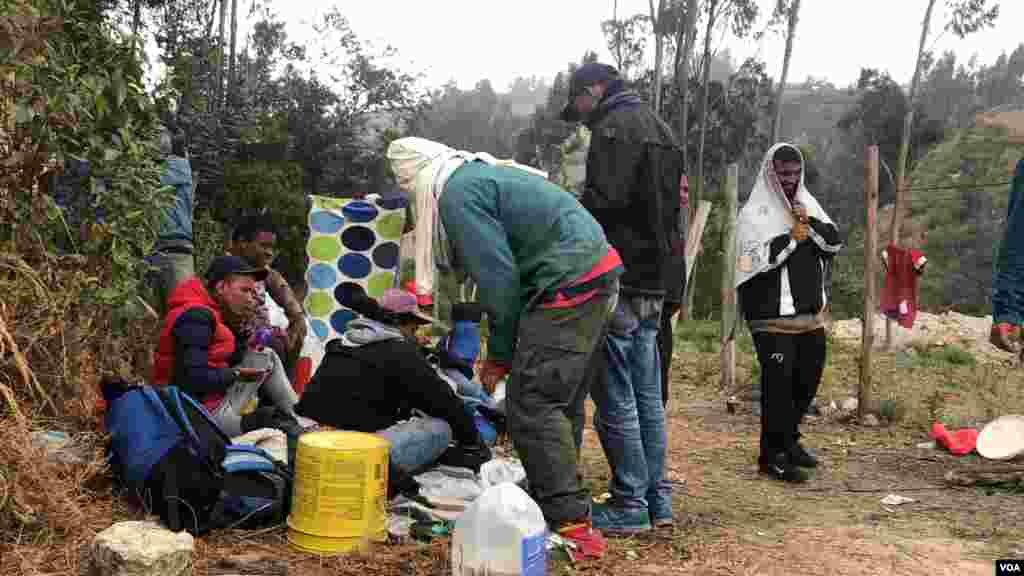 Un grupo de venezolanos espera mientras la frontera para Ecuador abre para ellos, tratan de mantenerse abrigados en medio del frío y se ayudan para poder comer. Ipiales, Colombia, 11 de septiembre de 2019. Foto: Celia Mendoza - VOA.