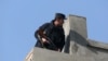 A member of the Afghan security force stands guard at the site of a suicide attack in Kabul, Afghanistan, Saturday, Nov. 28, 2015.
