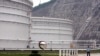 FILE - a security guard stands guard near oil tanks at Zhoushan Oil Reserve in Zhoushan in Zhejiang Province, China, June 30, 2009. Cooling economies in Asia and Europe also have weakened demand, sending the price below $50 for the first time since April.