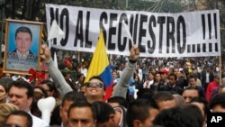 ARCHIVO - Personas marchan con un cartel que dice "No al secuestro" en protesta contra los secuestros en Bogotá, Colombia, el 6 de diciembre de 2011.
