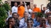 Meach Sovannara, center, a former spokesman of the opposition Cambodia National Rescue Party, receives holy water from a Buddhist monk on the outskirts of Phnom Penh, Cambodia, Tuesday, Aug. 28, 2018. Fourteen Cambodian opposition activists were freed Tue