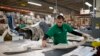 FILE - A worker manufactures car dash mats at a factory belonging to the TECMA group in Ciudad Juarez, Mexico, Dec. 27, 2013.