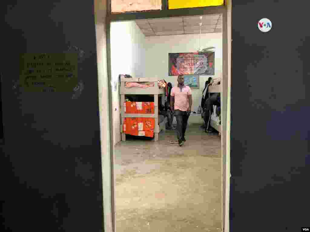 Un hombre de Africa que vive en este albergue en México camina de una habitación a otra, para que los hombres que llegan, puedan dormir. Photo: Celia Mendoza - VOA.