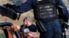 Rodeados de policías mexicanos fuertemente armados, miembros de la familia LeBarón, lloran a sus familiares muertos en una emboscada supuestamente realizada por narcotraficantes en Sonora, México, en octubre pasado. Foto AP
