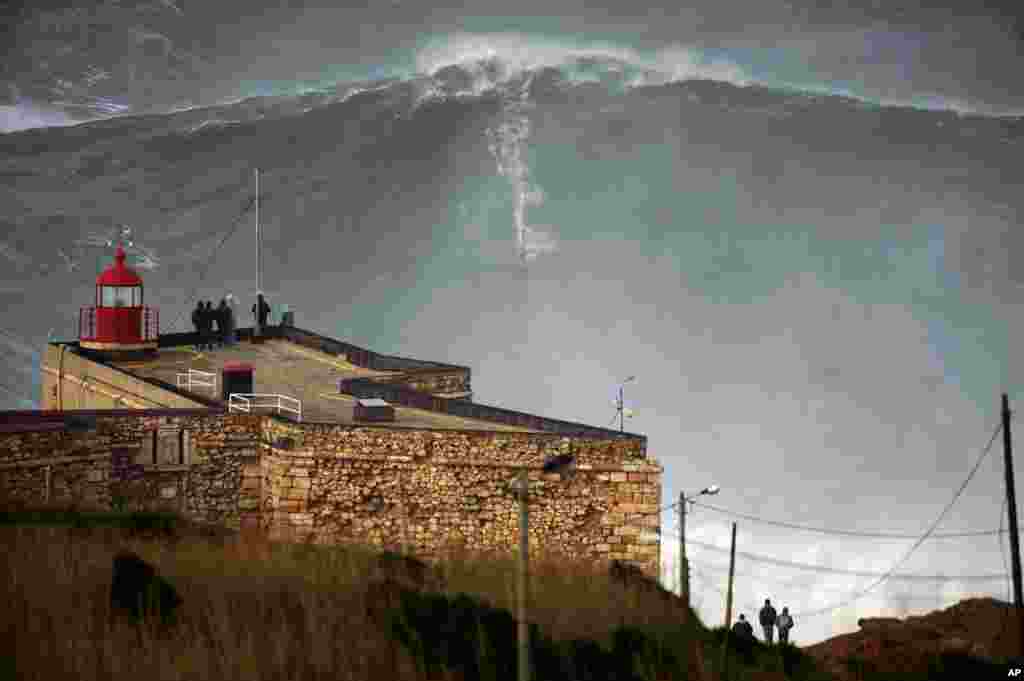 Ảnh chụp từ xa khi Garrett McNamara leo qua được ngọn sóng hơn 30 mét tại bờ biển Praia do Norte ở thành phố Nazare của Bồ Đào Nha.
