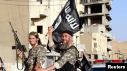 Phiến quân ISIL trong 1 cuộc diễu hành quân sự dọc theo các đường phố ở tỉnh Raqqa, phía bắc Syria, 30/6/2014.