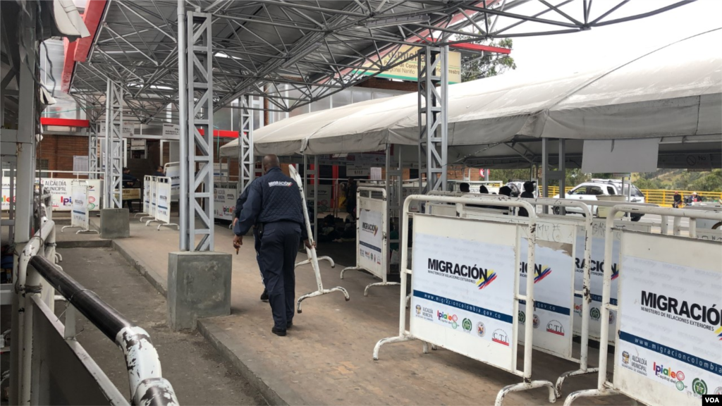 Los funcionarios de Migración Colombia eliminan algunas de las barreras ubicadas cerca de las carpas para evitar que los venezolanos las usen para colgar artículos personales. Ipiales, Colombia, 11 de septiembre de 2019. Foto: Celia Mendoza - VOA.